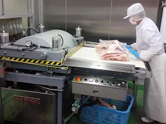 真空包装機に牛肉をセットする作業員